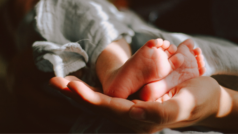 Image of a baby's feet being held by an adult's hand
