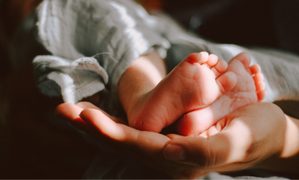 Image of a baby's feet being held by an adult's hand