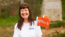 Volunteer at the Source to Sea community fundraising event, she is holding multiple MDUK flags